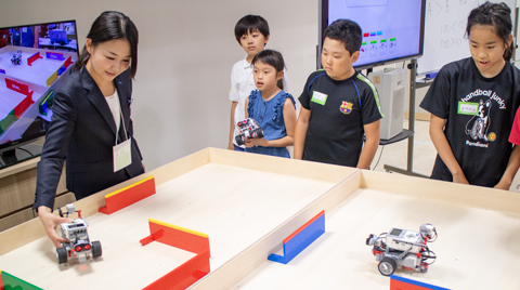ステージ上の障害物を避けるEV3 講師と小学生たちとEV3