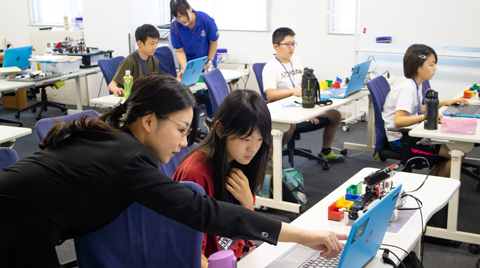 生徒にプログラムを教える講師 講師と小学生の生徒